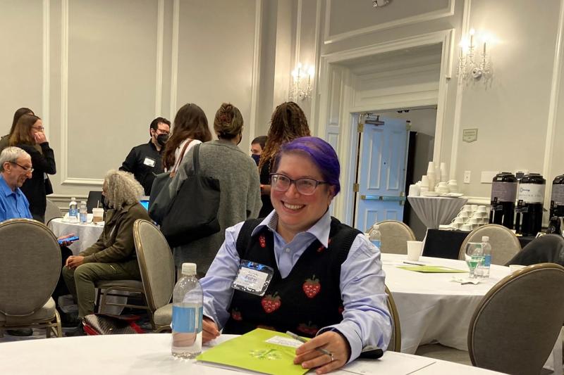 data camp attendee with purple hair sits at large round table