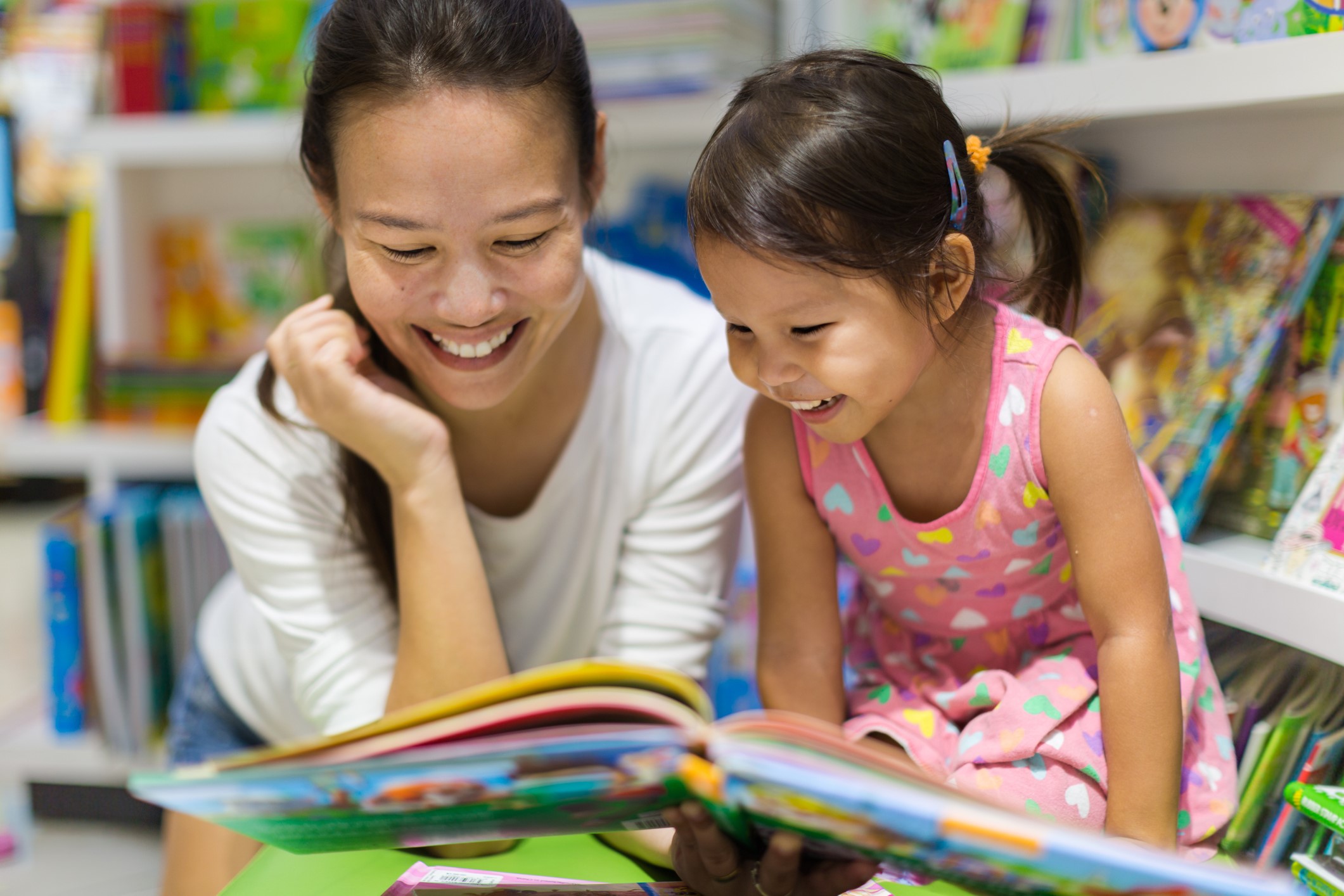 librarian reading to young girl in library