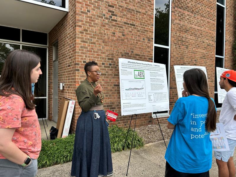 Danielle Spurlock, talks with data walk participants about rental housing market trends in Durham, NC.