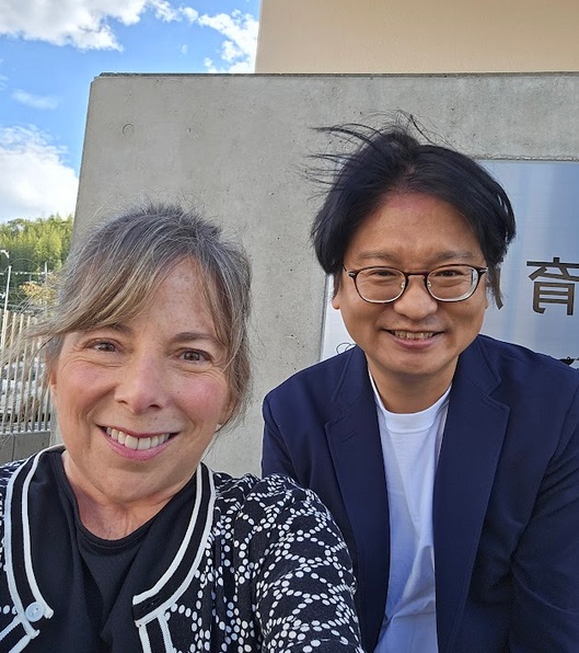 two people smile at camera; Jani Kozlowski at left and Ryutaro Shintani at right