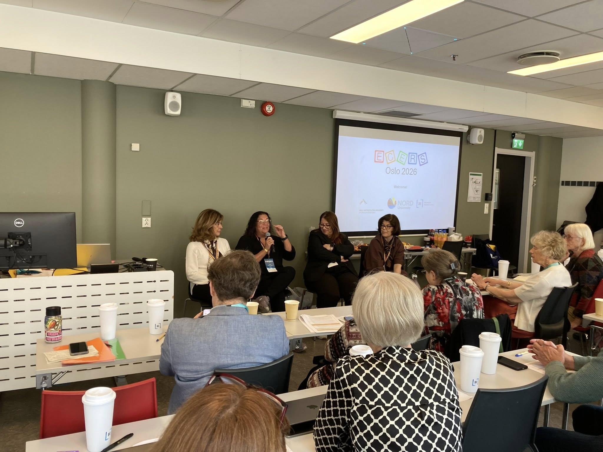 panel of four scholars share a discussion in front of small audience