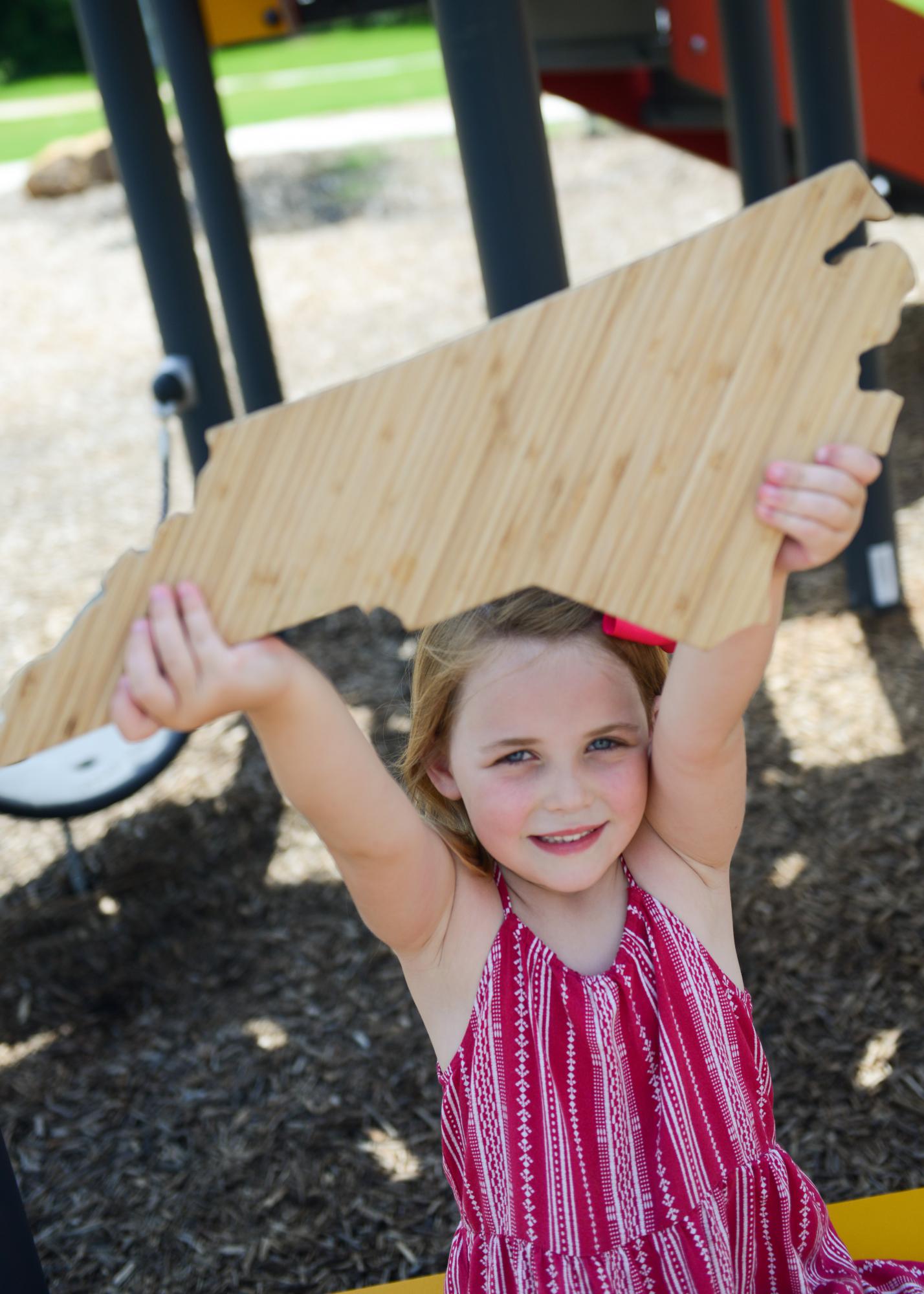 Young girl holding a North Carolina shape