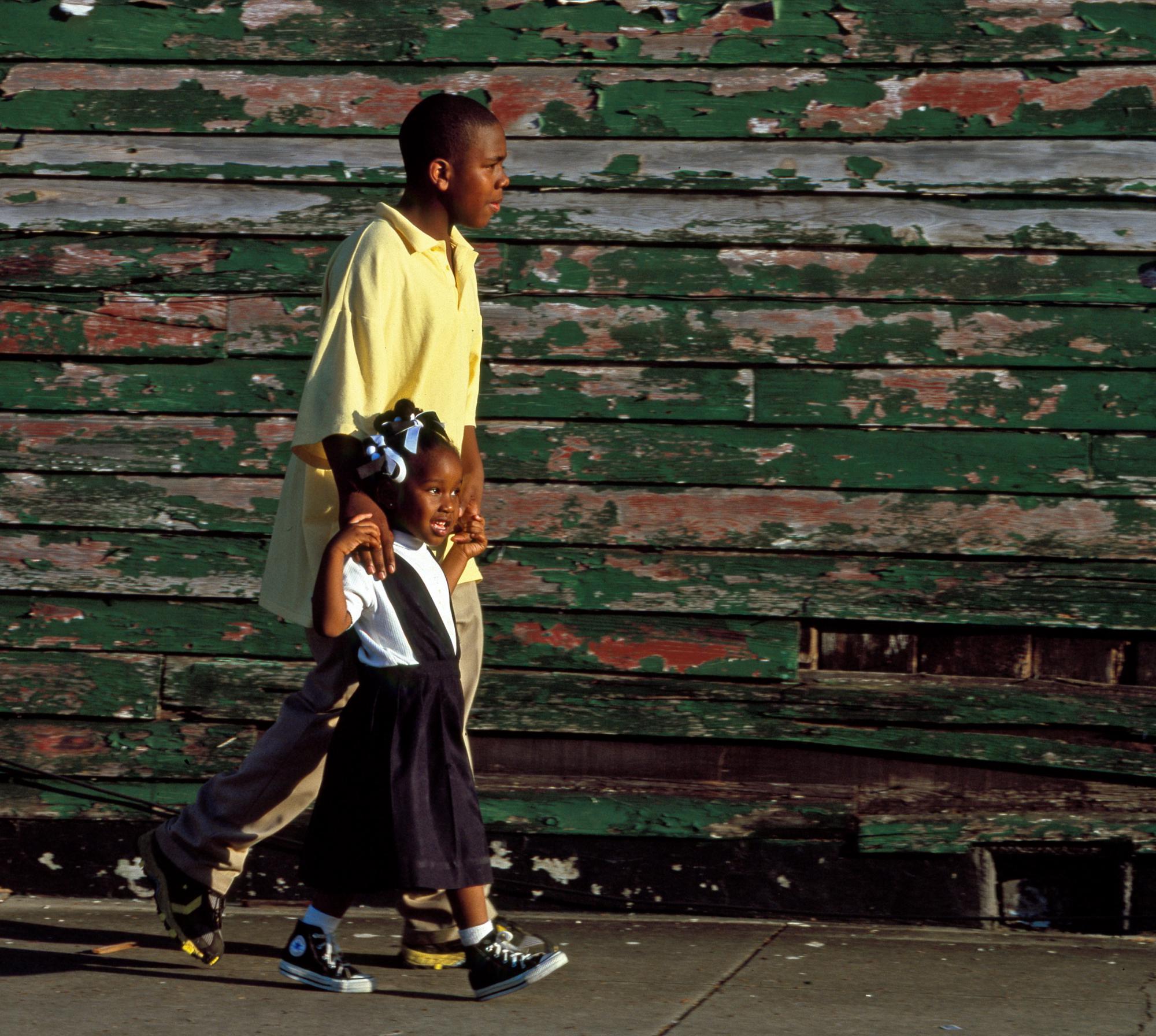 Older boy walking with younger girl