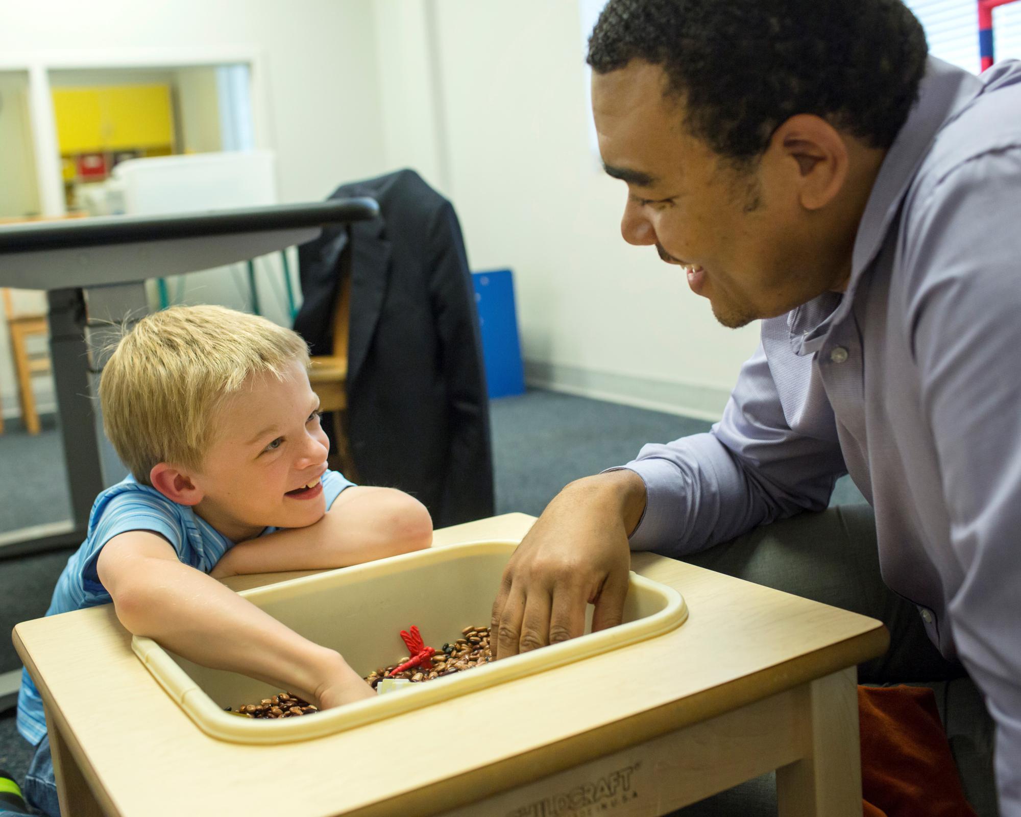 Teacher and child using sensory table