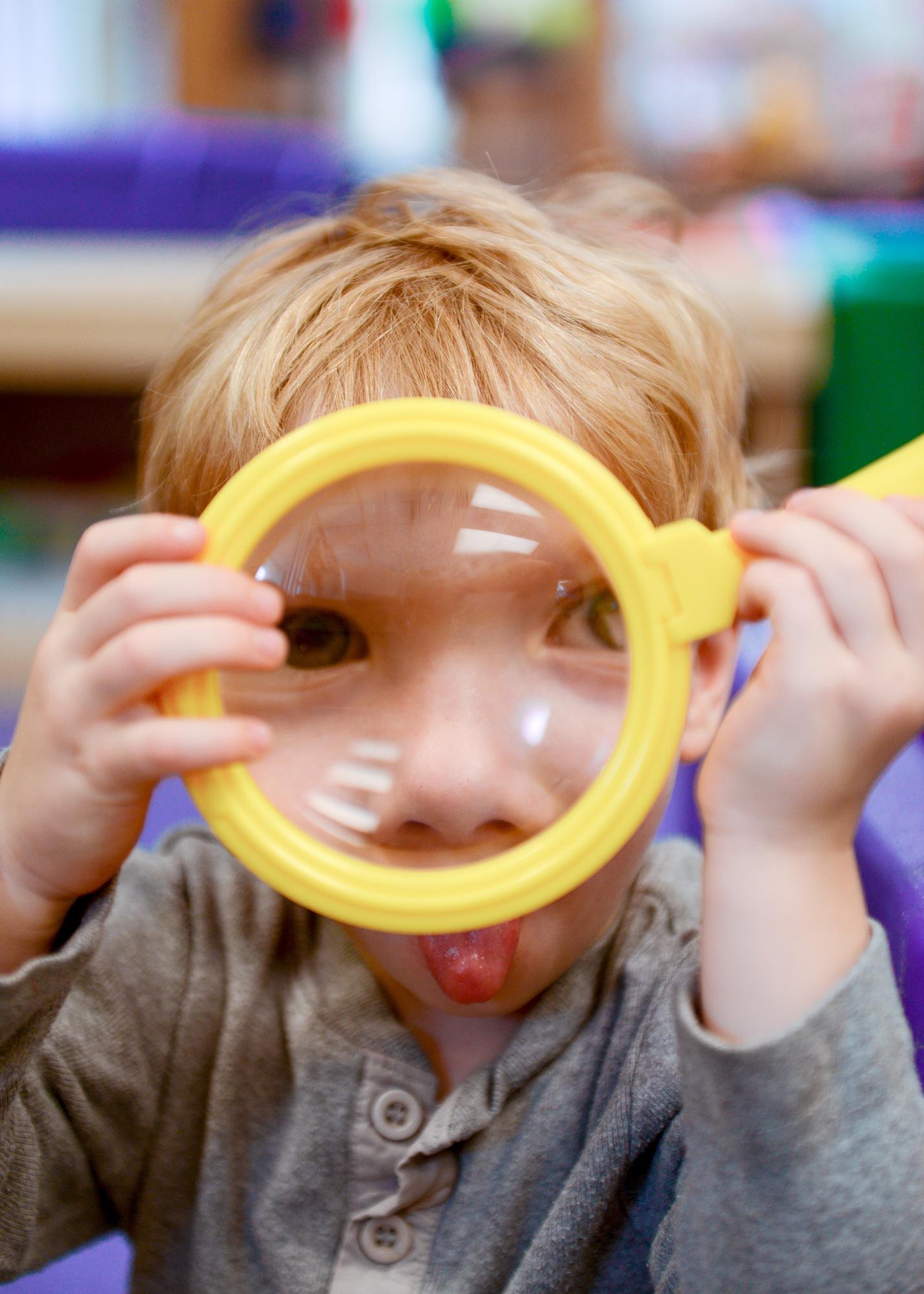 Young child with magnifying glass