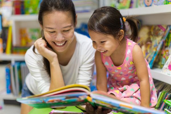 woman teaches young girl how to read
