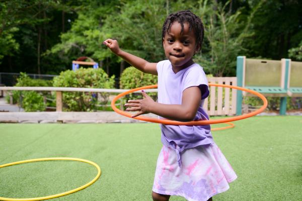 Young girl playing with hula hoop