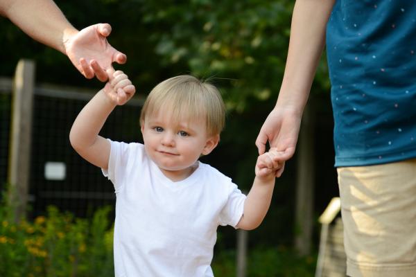 Boy holding hands with adults