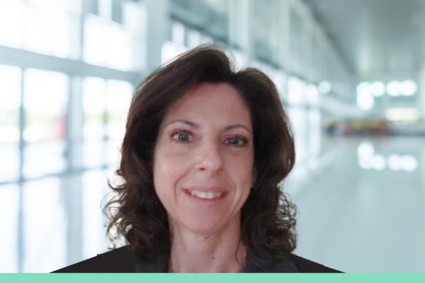 Kris Earl; headshot style photo of woman with shoulder-length brown wavy hair