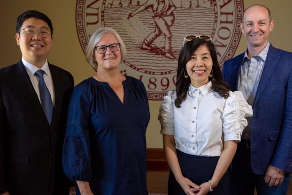 From far left, Wonkyung Jang, Diane Horm, Kyong-Ah Kwon, and Tim Ford stand together in front of OU seal