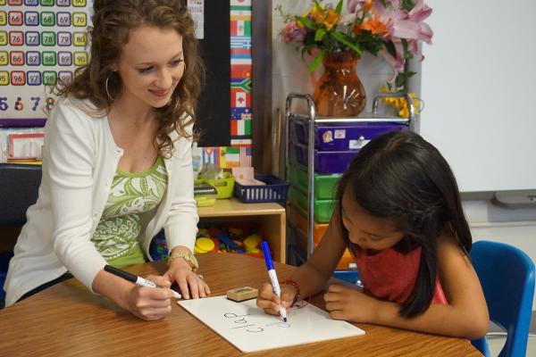 Adult and a child writing on paper