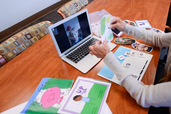 Adult showing a child a photo via webcam