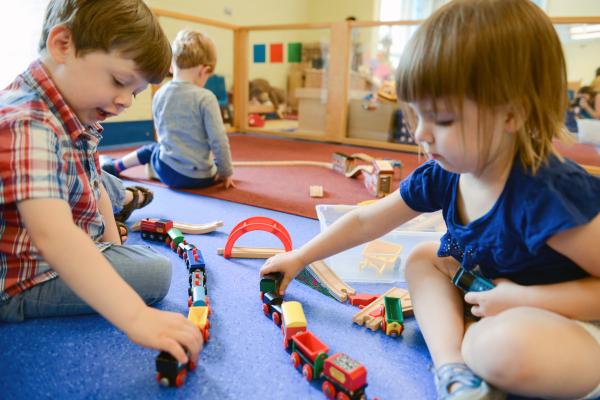 Two young children playing with trains