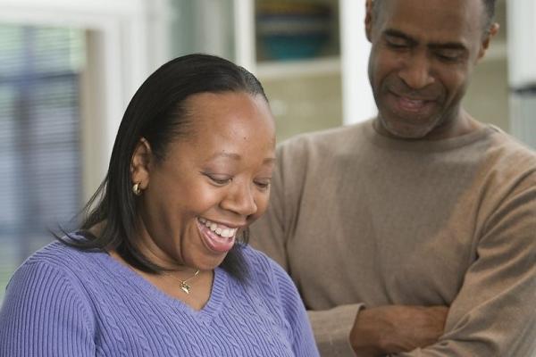 Two smiling adults standing near one another