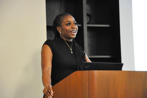 Amaya Jeffers stands behind a podium while giving a presentation