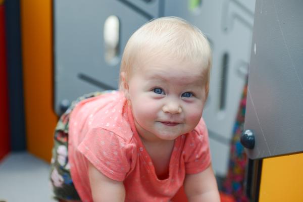 Smiling baby crawling on a play structure