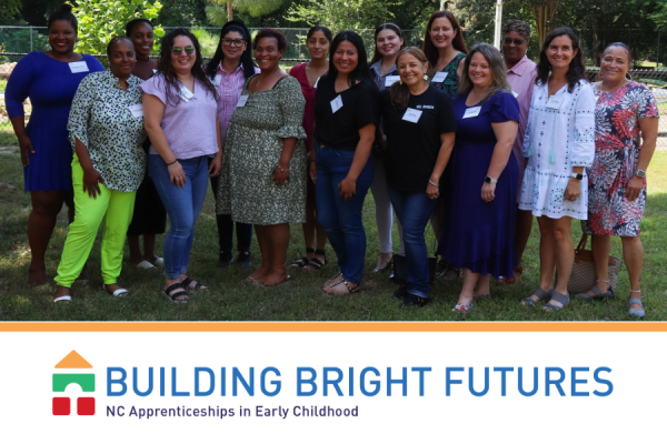 15 women stand outside in group photo; building bright futures logo beneath