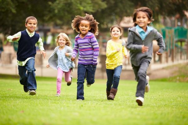 five young children running in park