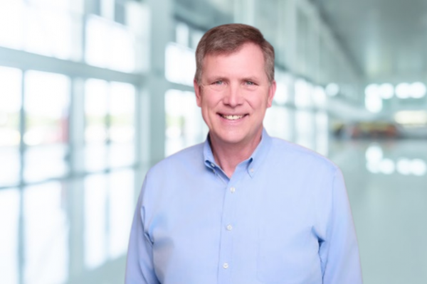 Dr. John Gilmore; man in light blue shirt smiles at camera
