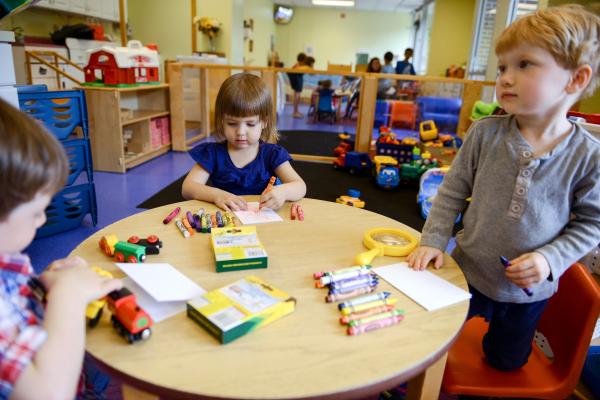 3 preschool students working at small round table