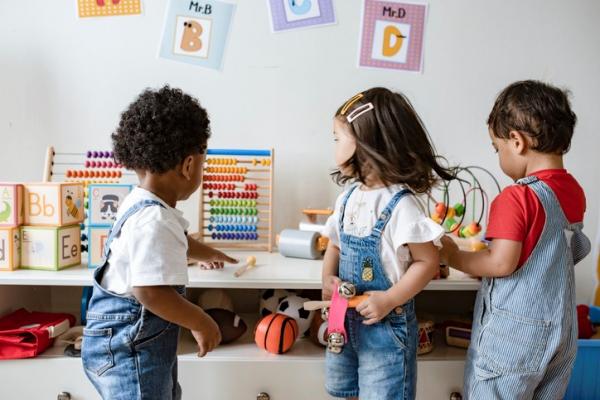 Three young children playing with educational toys