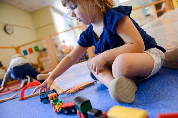 young child playing with train