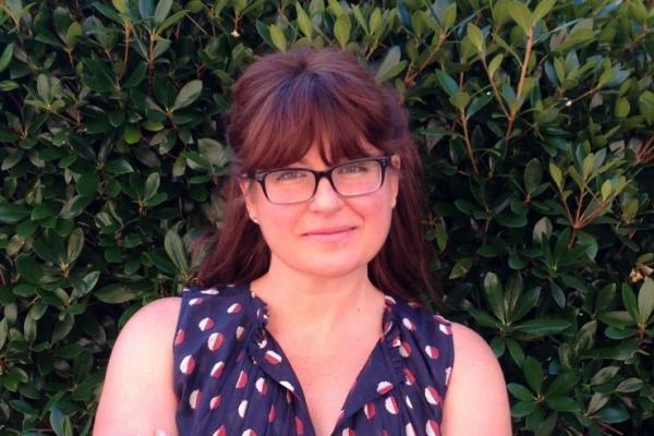 heather wasser; woman with shoulder-length auburn hair and glasses smiles at camera
