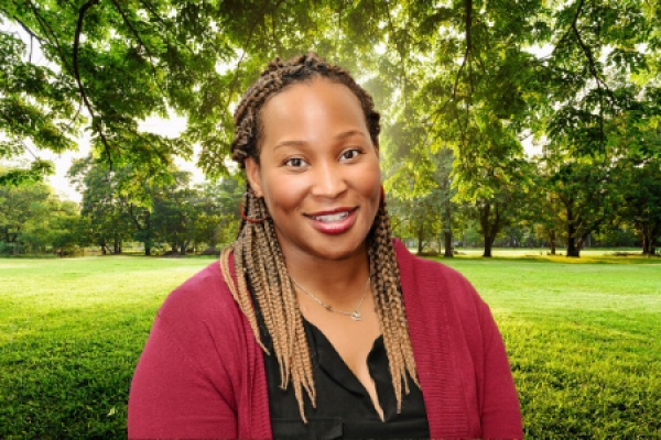 iheoma iruka; woman with long braided hair smiles at camera