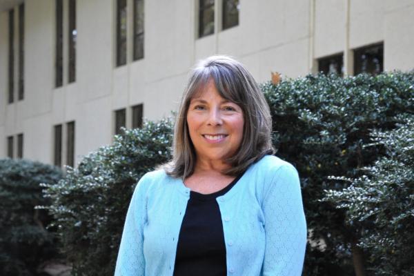 Jani Kozlowski; woman with shoulder-length hair and wearing a blue cardigan smiles at camera