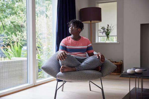 teenager sits in chair practicing mindfullness