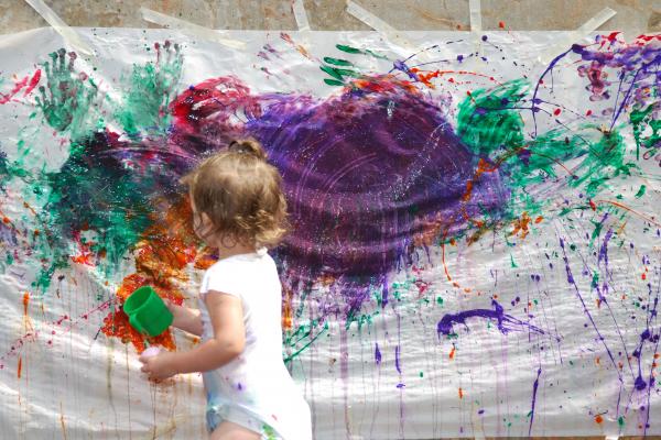 Young child painting a large sheet