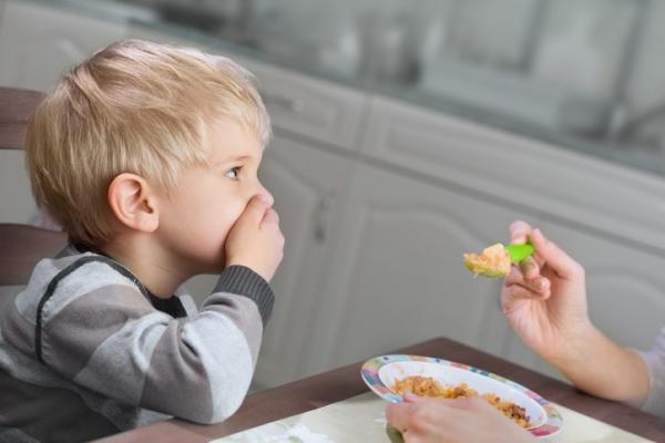 little boy refusing spoonful of food