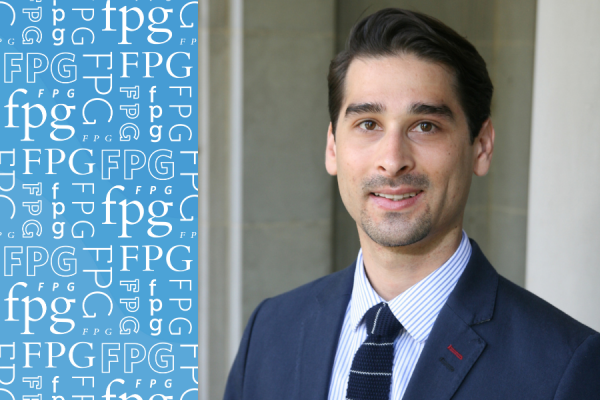 Robert Carr; headshot of man with dark hair wearing navy suit and tie to the right and on the left carlina blue background with fpg pattern repeated