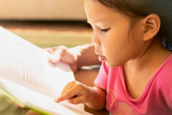 small child reading book 