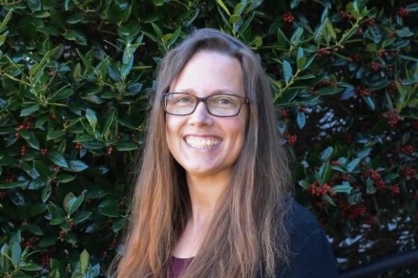 Victorial Waters; woman with long light brown hair and glasses smiles at camera