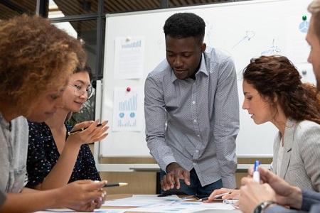 diverse group of 5 people working together at a table