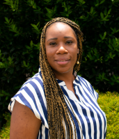 woman with long braided hair wearing blue and white striped blouse